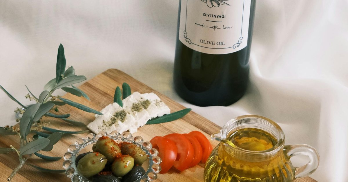 Bottles of Corfu olive oil with bread and olives on a wooden board