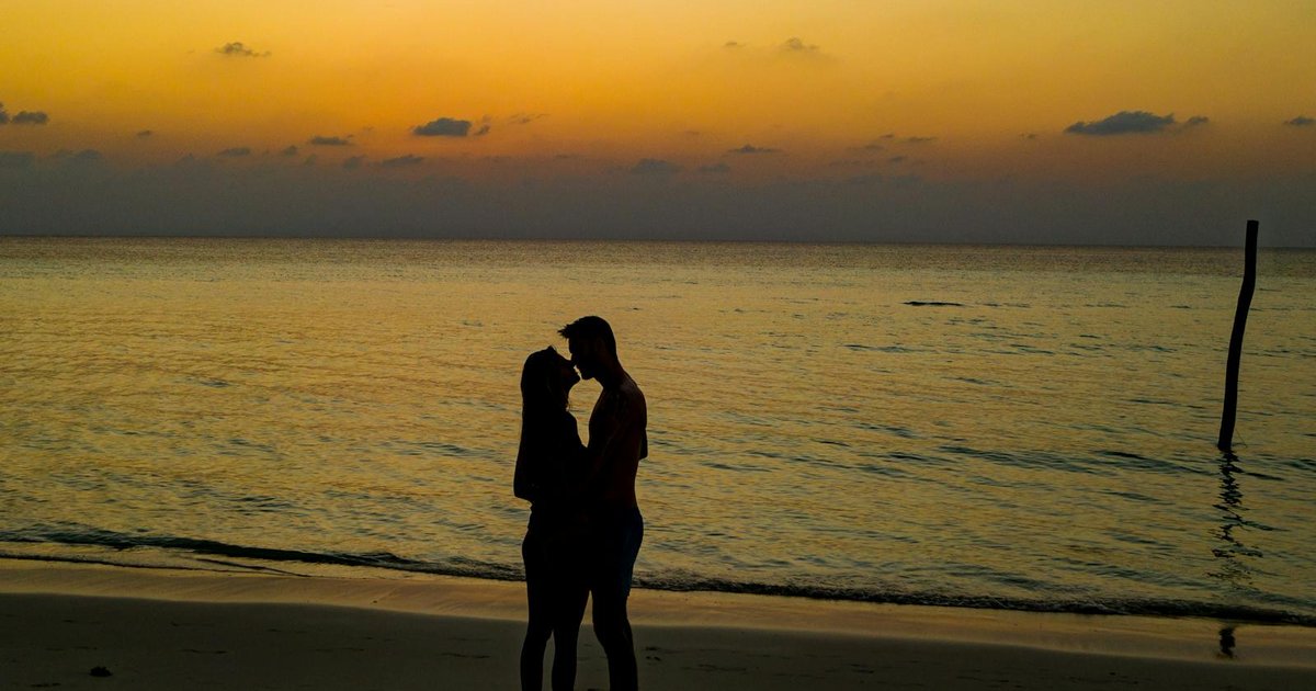 Couple alone on a quiet pebble beach in Corfu